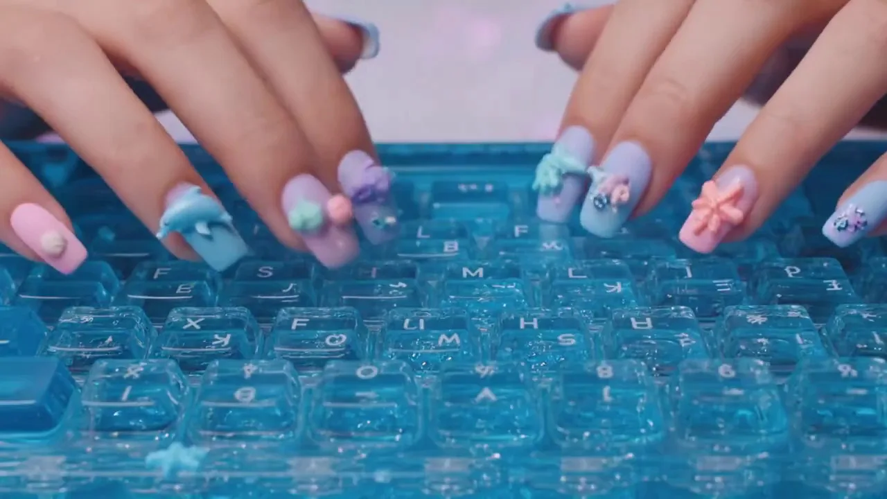 Close-up shot of hands typing on an ocean-blue transparent keyboard filled with water