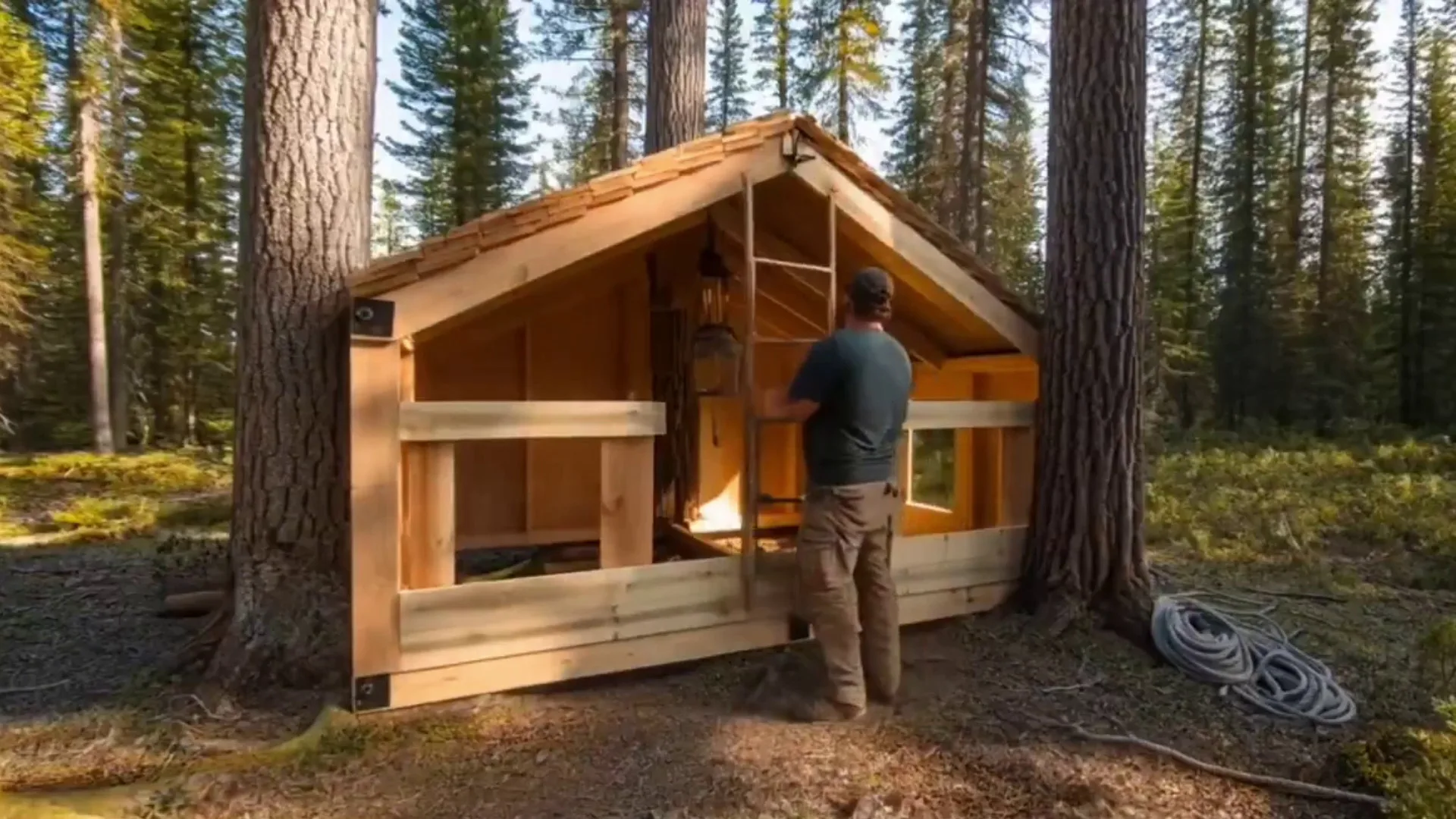 A rugged man stepping into a wild forest and built hideaway