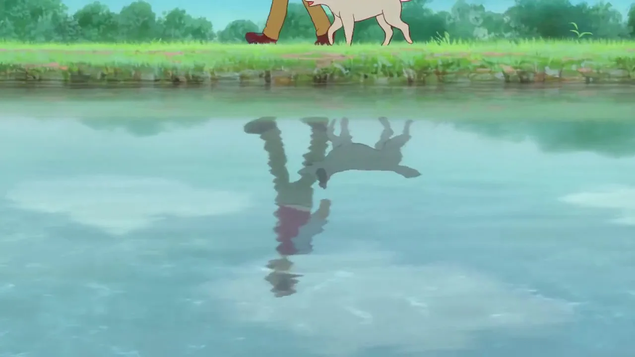 A boy walks beside a riverbank with a dog at his side